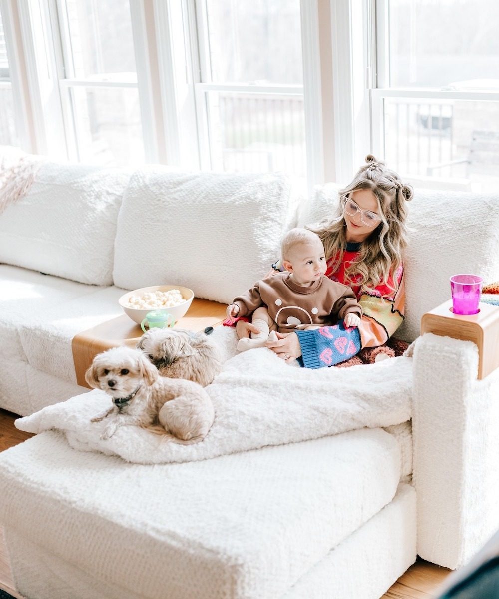 A mother and child lounge on a Lovesac sectional